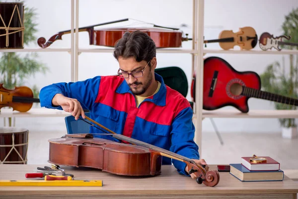 Jongeman Die Muziekinstrumenten Binnen Repareert — Stockfoto