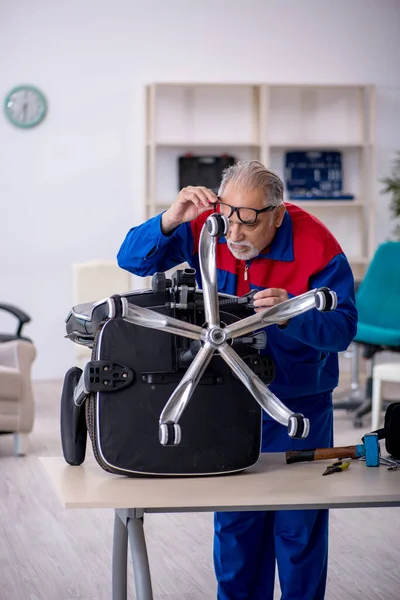 Old repairman repairing office chair