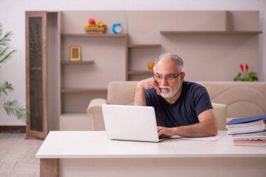 Yaşlı adam salgın sırasında evden çalışıyor.