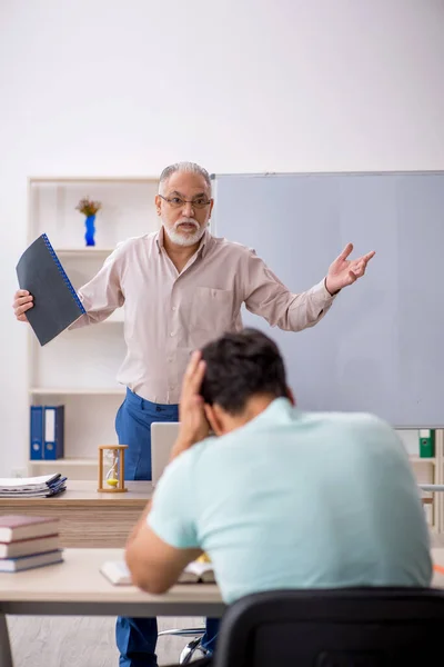 Old teacher and young student in the classroom