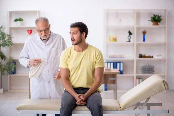 Genç Boyun Yaralı Hasta Yaşlı Erkek Doktoru Ziyaret Ediyor — Stok fotoğraf