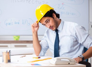 Beyaz tahtanın önündeki genç erkek mimar.