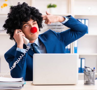 Ofiste çalışan genç palyaço işadamı.