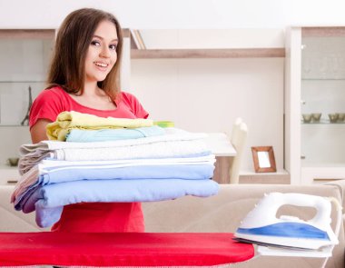 Genç güzel kadın evde Ütü