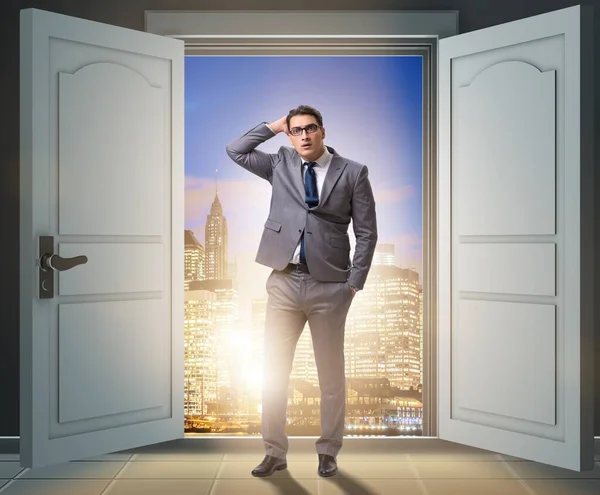 The puzzled businessman in front of big door