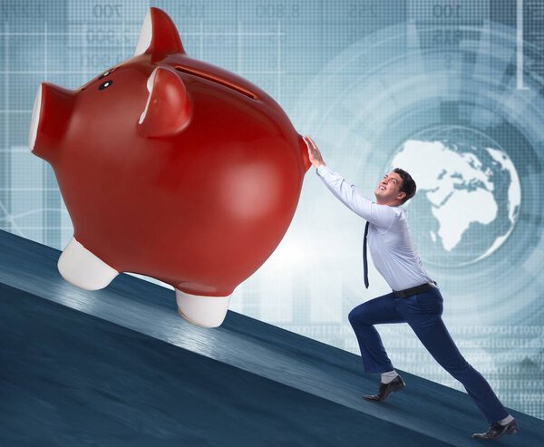 The man pushing piggybank uphill in business concept