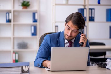 Genç işadamı ve ofiste çok fazla iş var.