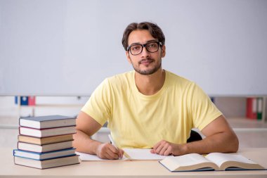 Sınıfta sınava hazırlanan genç bir öğrenci.