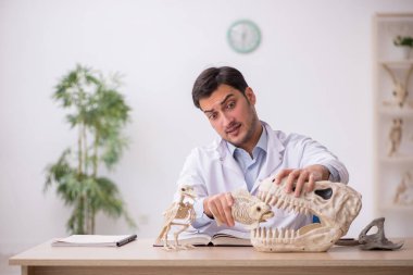 Genç bir paleontolog, laboratuvarda antik hayvanları inceliyor.