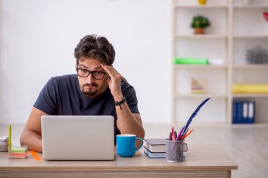 Genç tasarımcı ofiste çalışıyor.