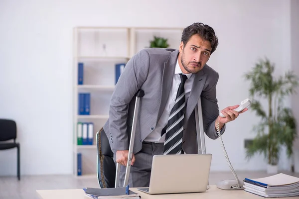 Young businessman employee after car accident working in the office