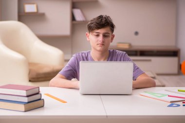 Erkek öğrenci evde sınava hazırlanıyor.