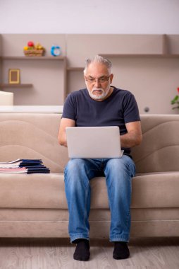 Yaşlı adam salgın sırasında evden çalışıyor.