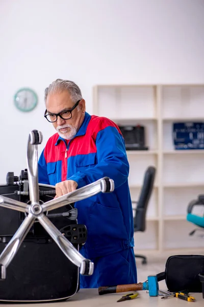 Old repairman repairing office chair