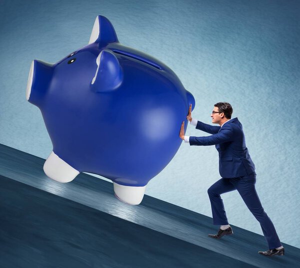 The man pushing piggybank uphill in business concept