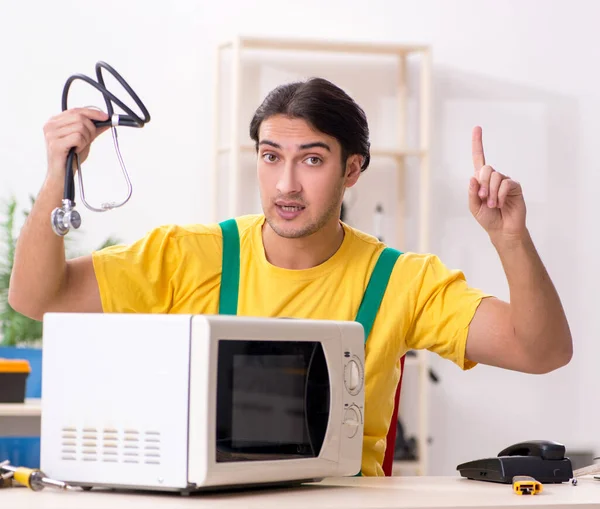 Young Repairman Repairing Microwave Service Centre — Stock Photo, Image