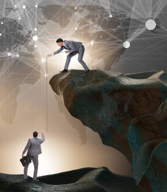 İş adamı, iş arkadaşına iple yardım ediyor.