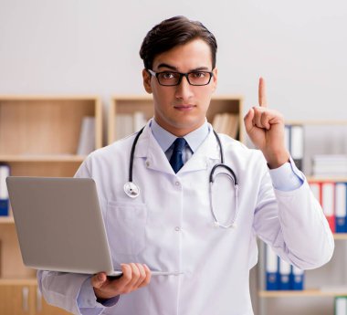 Dizüstü bilgisayarı olan genç bir doktor.