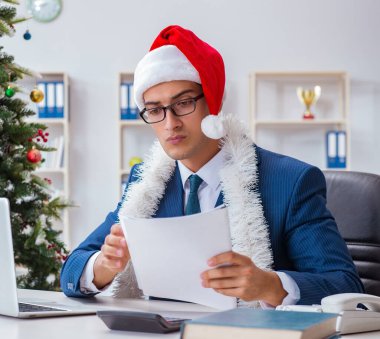 İş adamı Noel tatilini ofiste kutluyor.