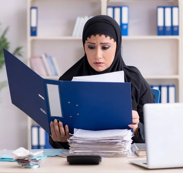 The female employee bookkeeper in hijab working in the office