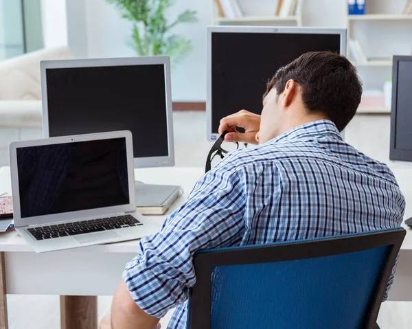 The businessman sitting in front of many screens