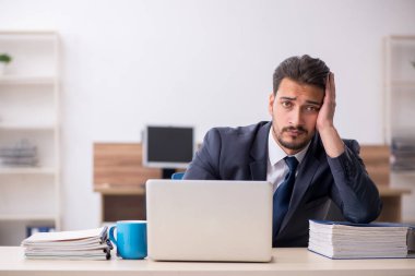 Genç işadamı işyerinde oturuyor.