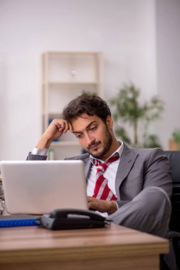 Genç işadamı ofisteki aşırı işten memnun değil.