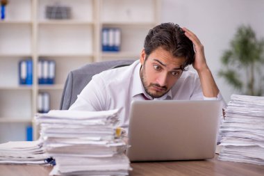 Genç işadamı ve ofiste çok fazla iş var.