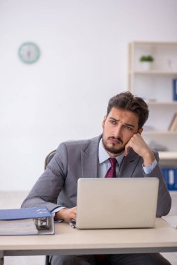 Genç işadamı işyerinde oturuyor.