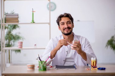 Klinikte çalışan genç bir dişçi.