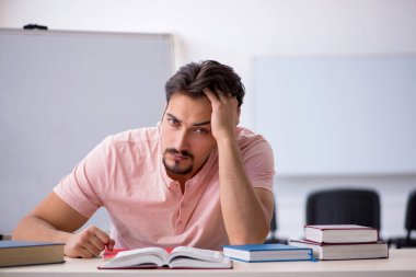 Sınıfta sınava hazırlanan genç bir öğrenci.