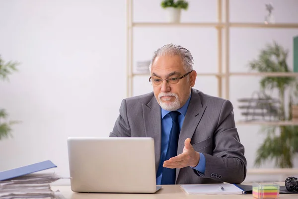 Old businessman employee working at workplace