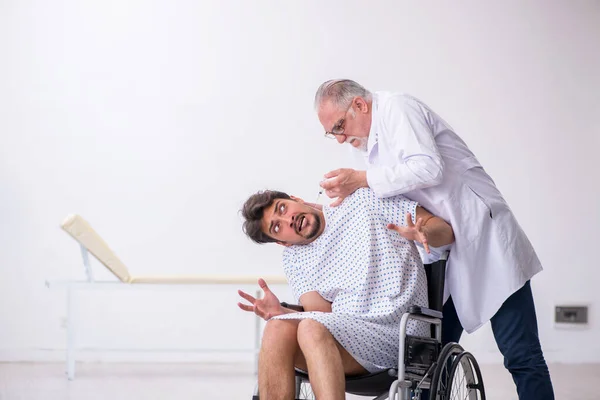 Old doctor psychiatrist examining young disabled patient