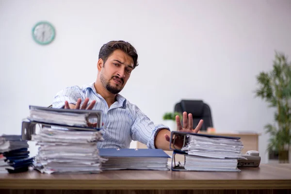 Young businessman employee unhappy with excessive work at workplace