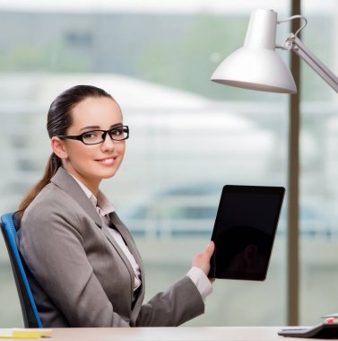 Tablet bilgisayarda çalışan iş kadını.