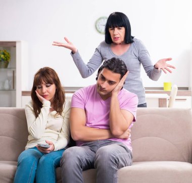 Aile sorunları konseptinde genç aile ve kaynana.
