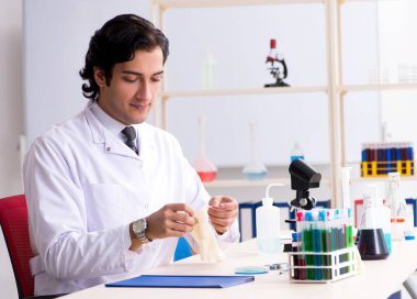 Laboratuvarda çalışan genç yakışıklı kimyager.