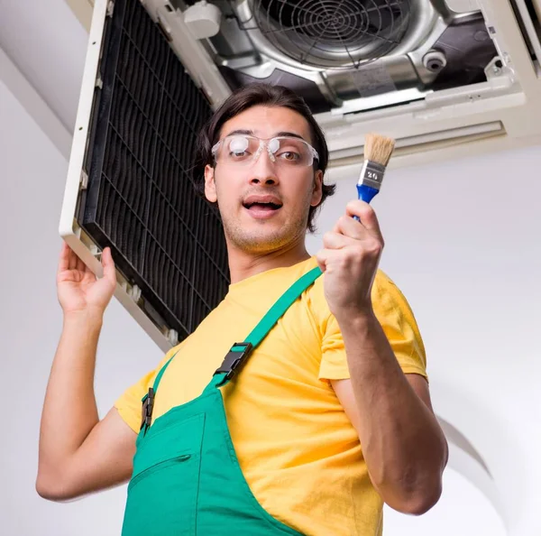Młody Mechanik Naprawia Klimatyzator Sufitowy — Zdjęcie stockowe