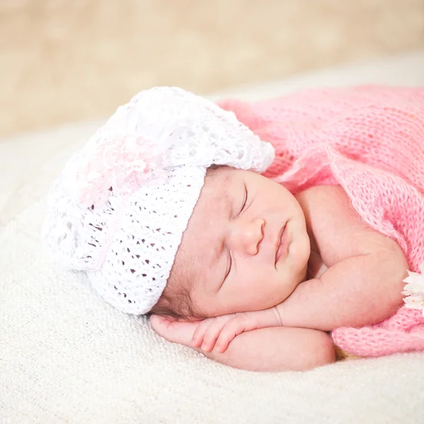 Newborn baby girl sleeping on green meadow among daisy — Stock Photo