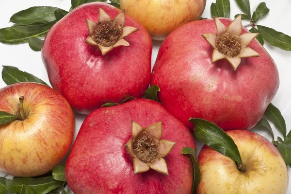 Granadas frescas maduras y manzana con hojas — Foto de Stock