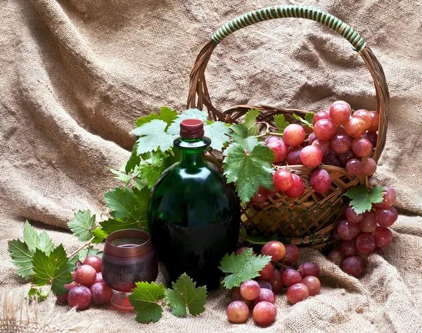 Víno a červené hroznové listy v košíku — Stock fotografie