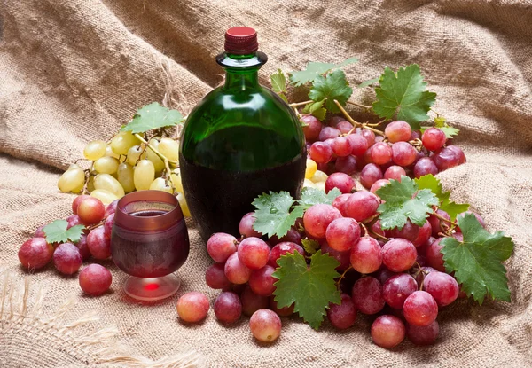 Červený hrozen s listy a víno — Stock fotografie