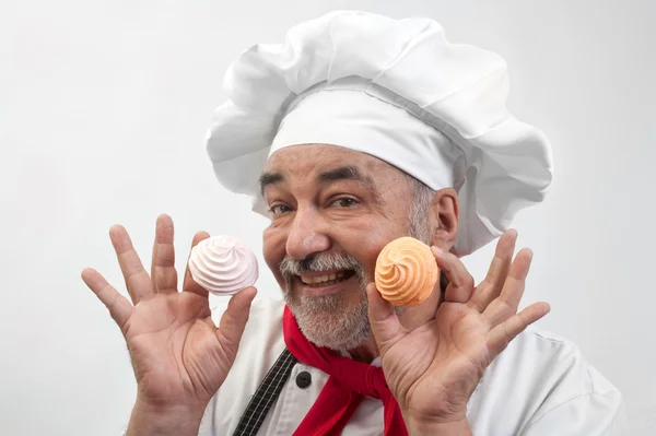 Smiling chef with colored meringues — Stock Photo, Image