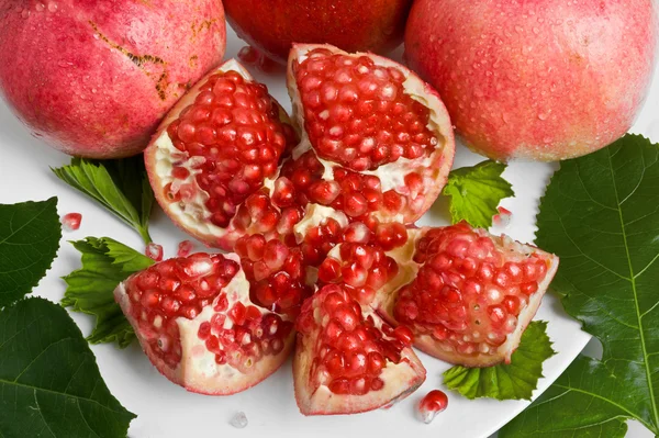 Ripe fresh pomegranates with leaves — Stock Photo, Image