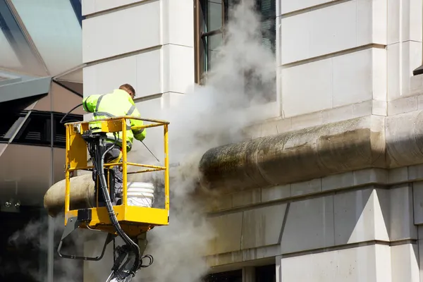 Ein Arbeiter wäscht die Fassade — Stockfoto