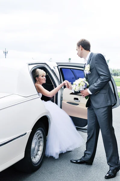 Joven mujer feliz caucásica en vestido de novia hermoso blanco sentado en el coche —  Fotos de Stock