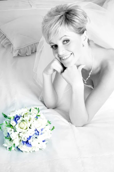 Beautiful bride with stylish make-up and hairdo holding bouquet in her hand — Stock Photo, Image
