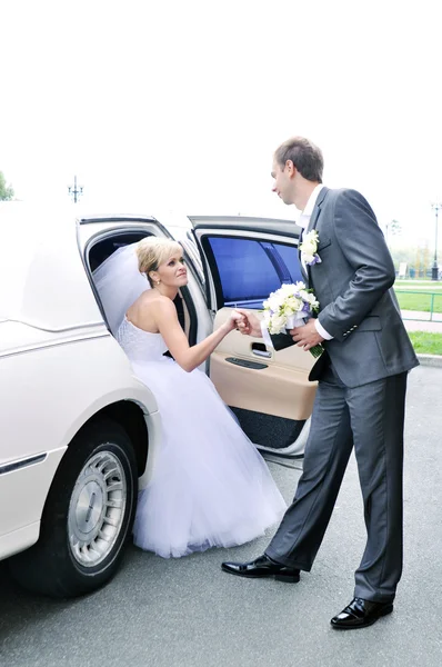 Young Caucasian happy woman in white gorgeous wedding gown sitting in car Royalty Free Stock Images