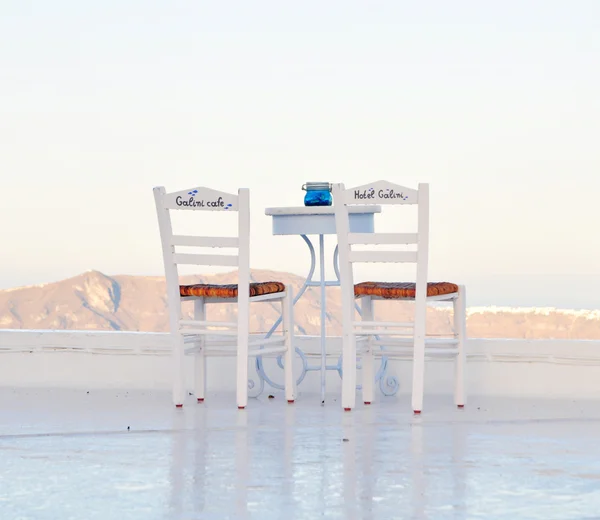 Zwei stühle und tisch auf der terrasse von fira, santorini, griechenland — Stockfoto