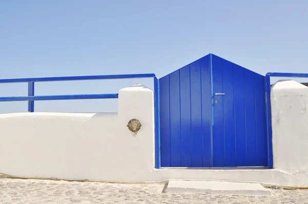 Modré dřevěné dveře a jasné modré nebe na santorini island, Řecko — Stock fotografie